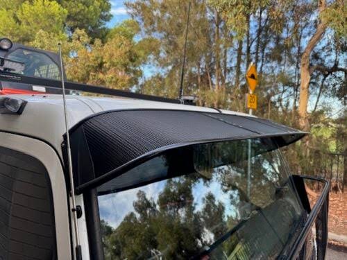 An alloy sun visor provides a lightweight corrosion proof cab shade